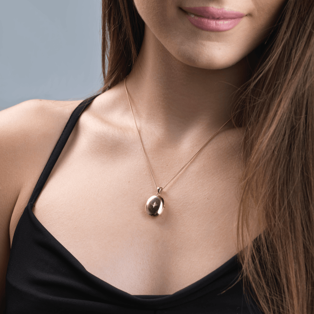 Model wearing a 9 ct gold 4-photo oval locket set with a diamond on a 9 ct gold curb chain