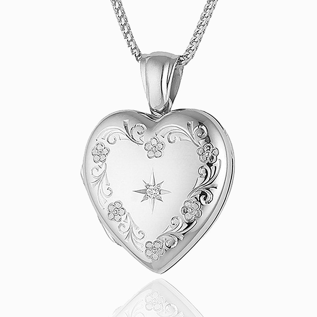 an 18 ct white gold heart locket star set with a diamond in the middle and a floral engraving around the edge, on an 18 ct white gold franco chain