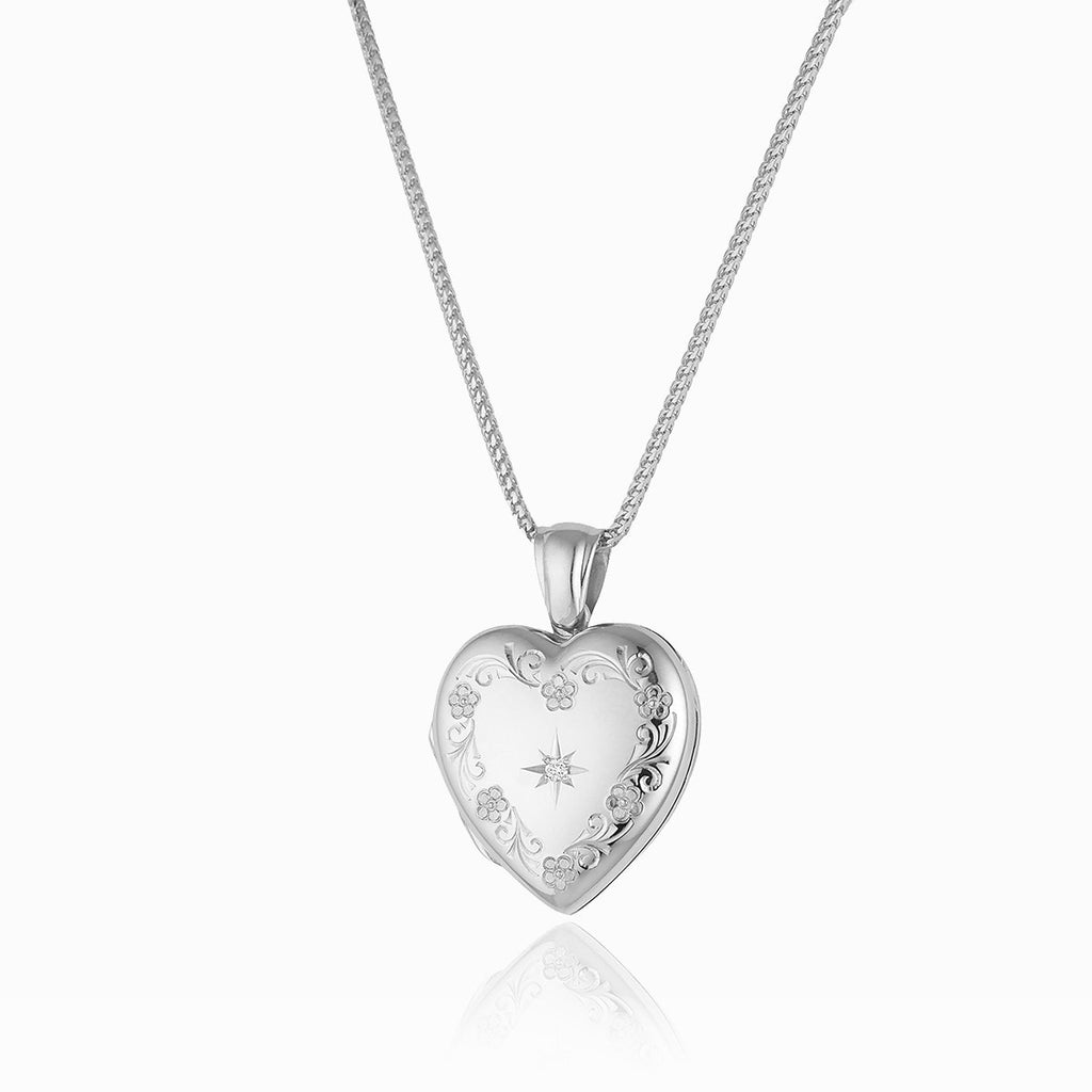 18 ct white gold heart locket with an engraved floral border and a star set diamond in the middle, on an 18 ct white gold franco chain