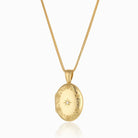 18 ct gold oval locket engraved with a floral border and star set with a central diamond, on an 18 ct gold franco chain.