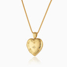 18 ct gold heart locket with an engraved floral border and astar set central diamond on an 18 ct gold franco chain