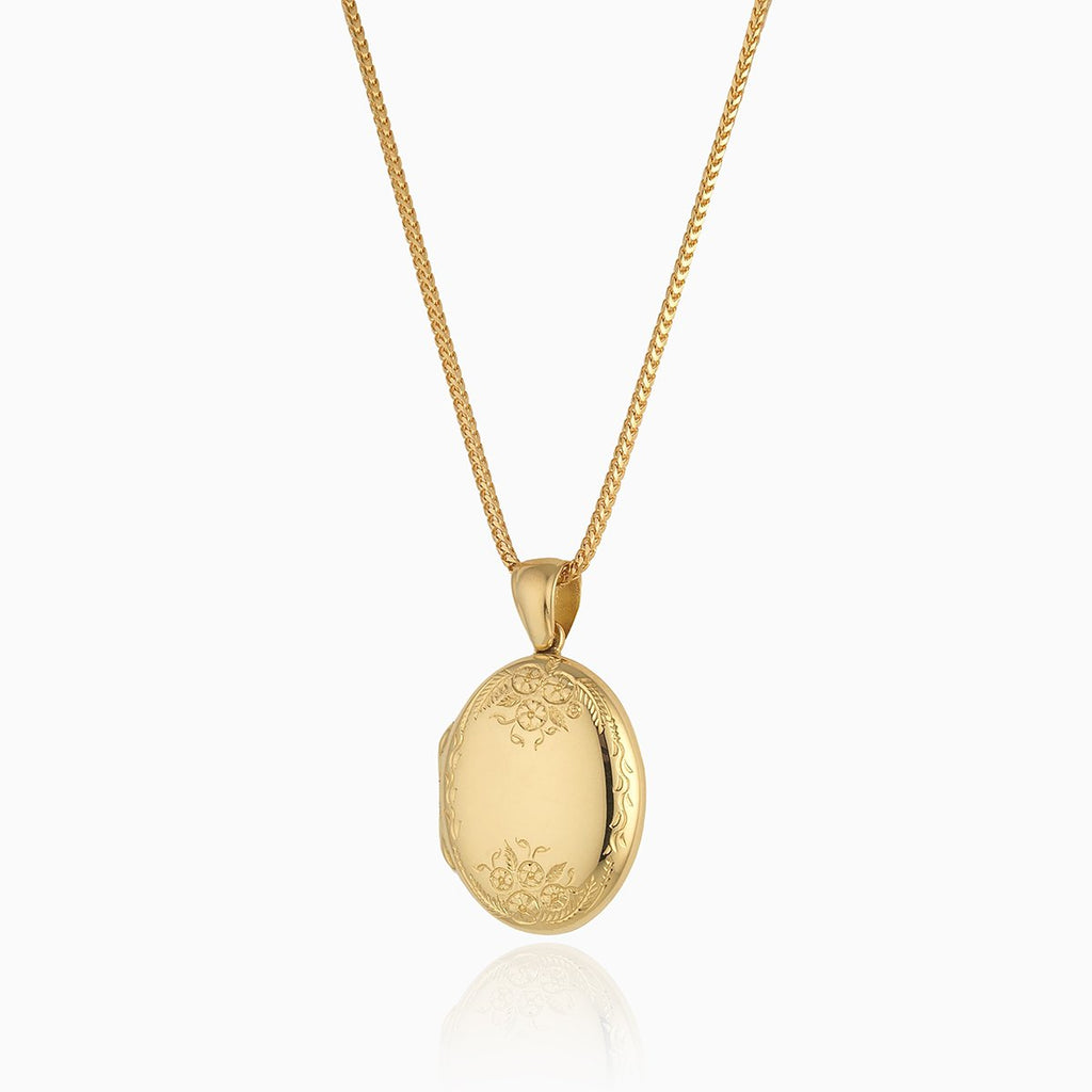 18 ct gold oval locket engraved with a floral design at the top and bottom of the locket, on an 18 ct gold franco chain