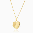 9 ct gold heart locket with a satiin and polished design on the front on a 9 ct gold curb chain