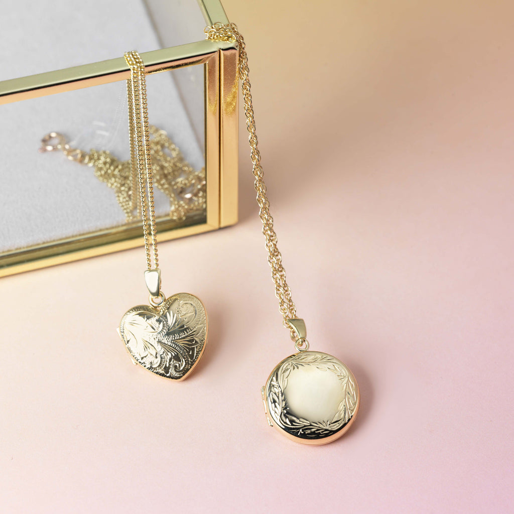 one gold heart locket engraved with a foliate design, and one gold round locket with a foliate border, both on 9 ct gold chains