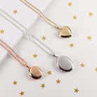 three lockets lying in a row, one rose gold oval, one silver large oval and one gold heart