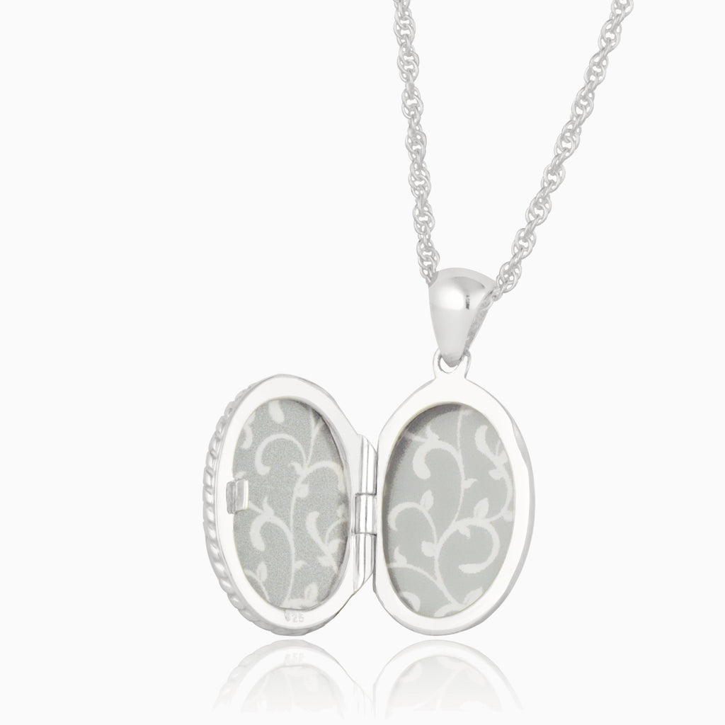 open view of a sterling silver oval locket with paper inserts